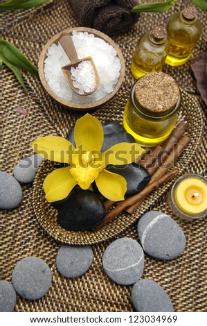 Spa setting with salt in bowl and candle ,massage oil ,orchid