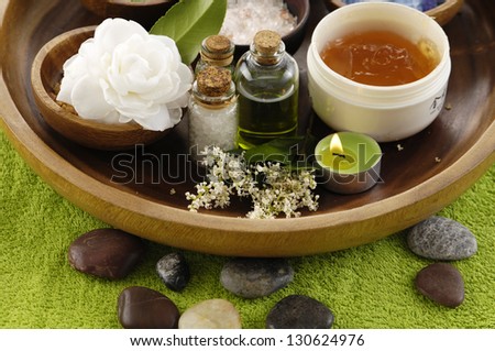 sea salt in wooden bowl with Gardenia flower ,massage oil ,candle on green towel
