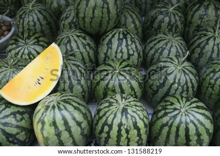Many sweet yellow watermelons and one cut watermelon