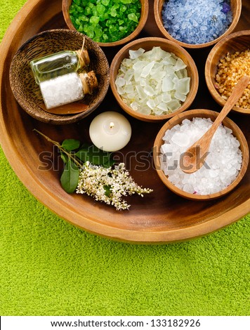 color sea salt in wooden bowl with flower ,massage oil on towel