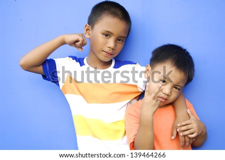 Two brothers with loving hug on blue