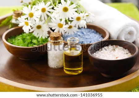 color sea salt in wooden bowl with and salt in glass, massage oil ,towel on board