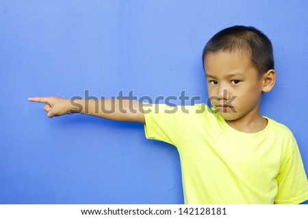 little boy with index finger up on blue background