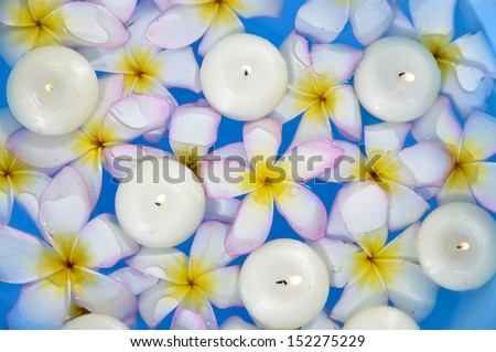 Top view many frangipani with white candle in the water