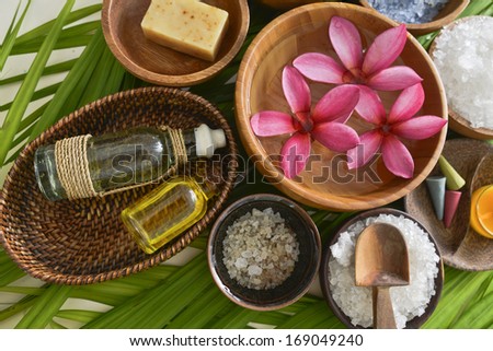 sea salt in wooden bowl with perfume ,massage ,soap oil on palm
