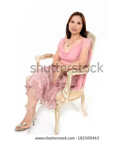 middle aged woman women sitting in a antique chair posing on white background