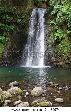 Beautiful small waterfall flows into the forest pond at the end of the hiking path of Faial da Terra, Sao Miguel, Azores.