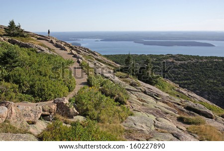 A person enjoying the view from on top of Cadillac Mountain.  Located on Mount Desert Island - Acadia National Park, Maine, USA.