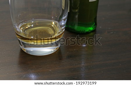 A small amount of scotch whisky sitting on a table.