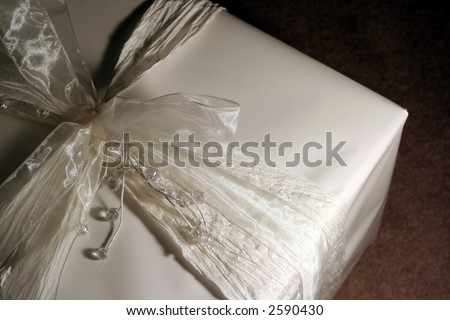 A closeup of a beautifully wrapped wedding gift.