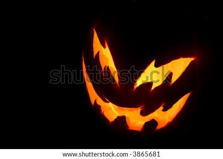A spooky pumpkin face glowing on Halloween night.