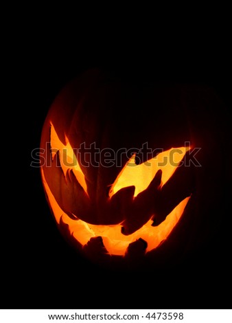 A spooky pumpkin face glowing on Halloween night.