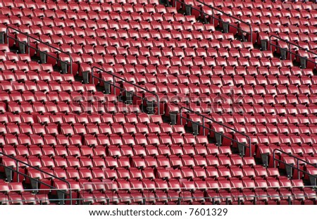 Red staduim seats cast in bright sunshine.