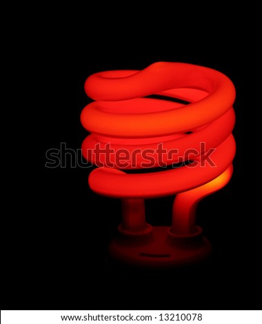 A red compact flourescent energy saver light bulb set against a black background.