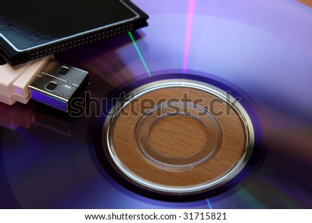 Three different pieces of media storage. (USB stick, compact flash and a DVD)