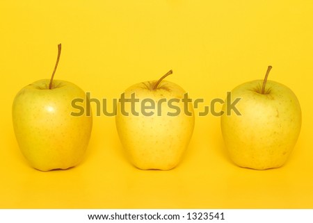 Three apples on a yellow background