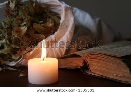 Things on table - a burning candle, a book, etc.