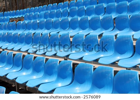 Several rows of blue stadium seats