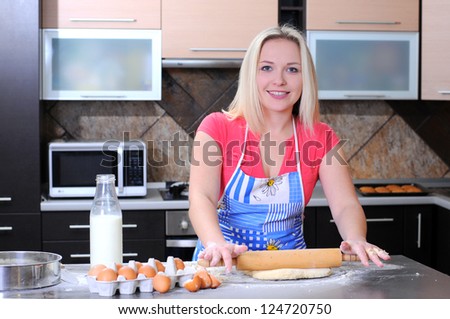 Female cook rolling dough with rolling-pin