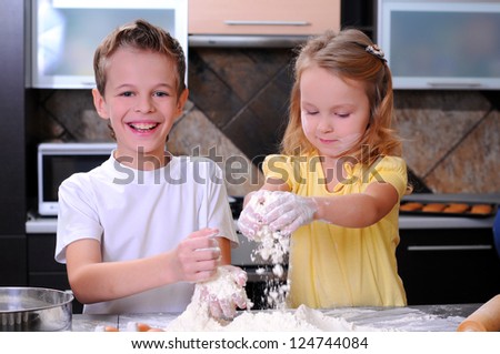 Kids preparing the dough for a cookie, pizza or pasta - having fun breaking the eggs