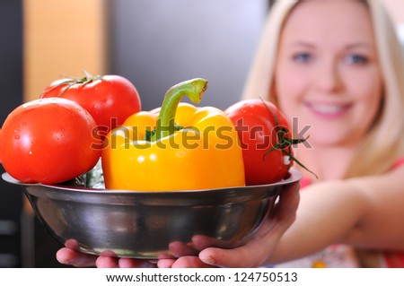 Woman holding a bowl of vegetables. Vegetables in Focus
