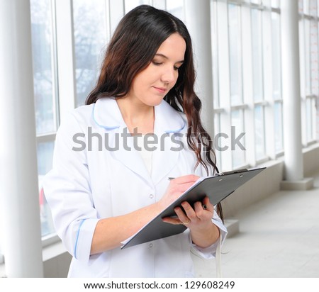 Portrait of a female doctor against modern hospital building