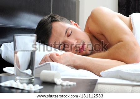 Man sleeping - pills on bed table