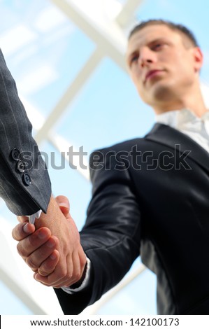 Business man giving a handshake to close the deal