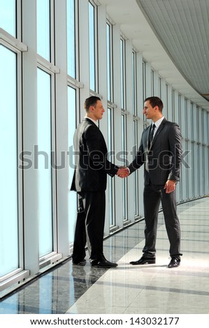 Cheerful businesspeople, or businessman and client, handshaking