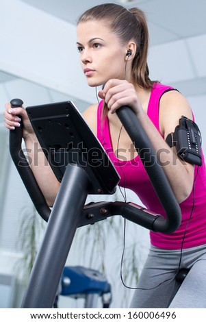 Fitness Woman. Young sporty woman doing exercise on bicycle in the gym centre.