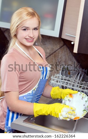 Kitchen Woman. Modern kitchen - happy woman washing dishes, housework