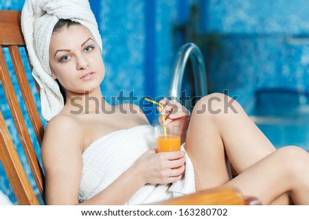 Spa & Wellness. Closeup of pretty smiling woman with juice glass in spa salon