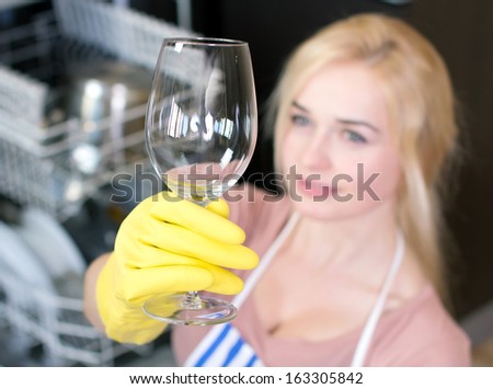 Kitchen Woman. Girl in the kitchen using dishwasher. view of young woman in kitchen doing housework. see clean the glass