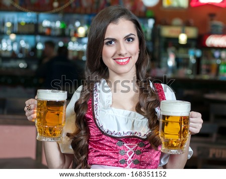A pretty waitress with beers at the bar