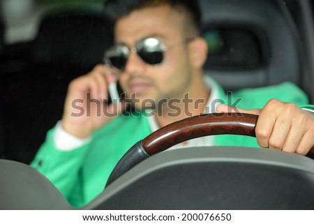 Portrait of young Indian business man, driving a car