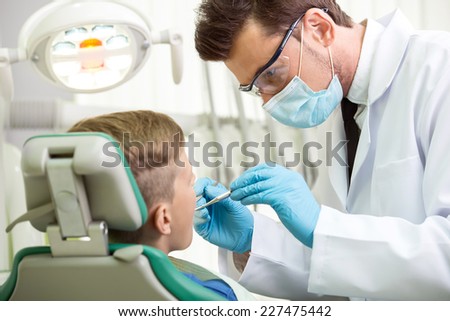 The doctor treats a tooth of little boy at dentist\'s clinic.