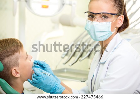 The female doctor treats a tooth of little boy at dentist\'s clinic.
