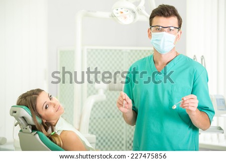 Friendly dentist with female patient on regular visit at dental surgery.