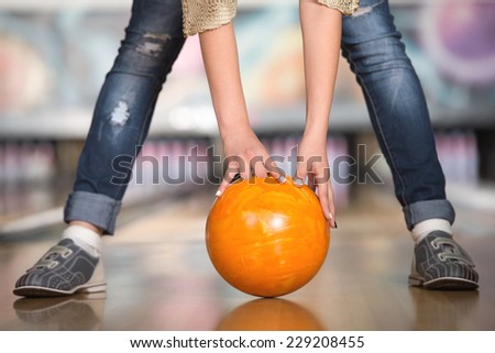 Woman in bowling alley. A woman is having fun while playing bowling.