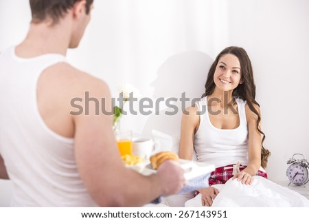 Husband bringing the breakfast to his wife in bed.