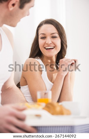 Husband bringing the breakfast to his wife in bed.
