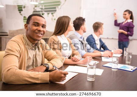 Confident business woman in meeting at office with team.