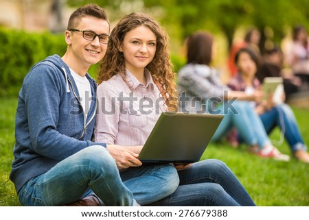 Couple of attractive smiling students dressed casual having fun outdoors on campus at the university.