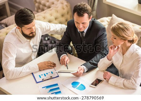 Businessman explaining a financial plan to colleagues at meeting.