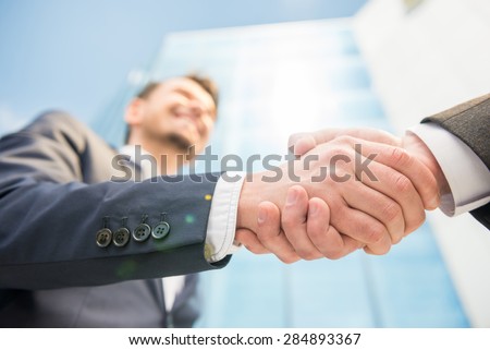 Closeup of two successful smiling business men shaking hands.