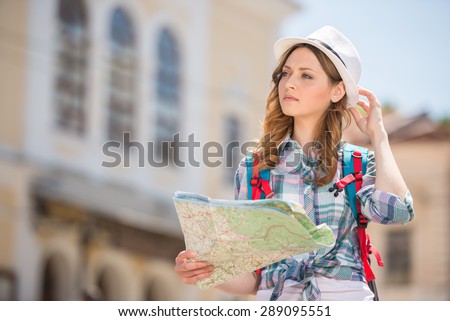 Woman lost in old european city holding a map.