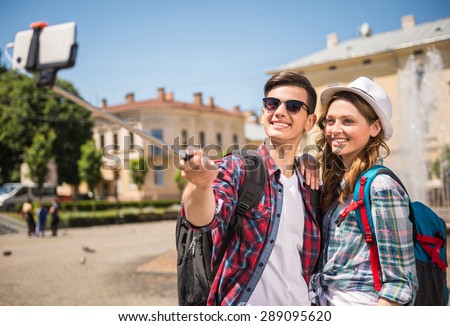 Happy travelers making selfie in the street of old european city.