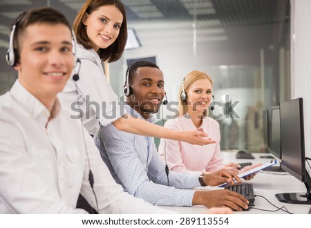 Beautiful female manager helping call centre agent.