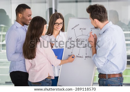 Group of young colleagues dressed casual standing together in modern office and brainstorming.