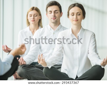 Tired business people sitting in yoga pose at office.